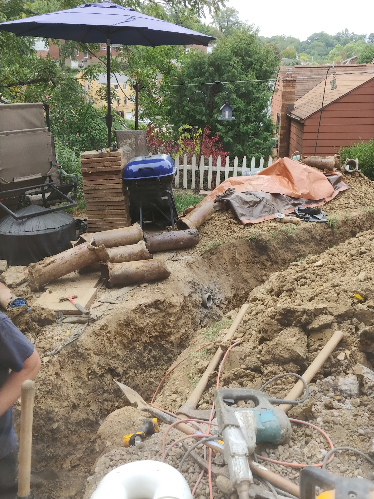 Old terracotta sewer pipe dug up and removed from a backyard trench during a sewer line replacement